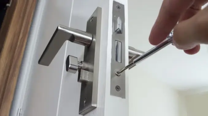 Serrurier professionnel installant une nouvelle serrure haute sécurité sur une porte d'entrée.